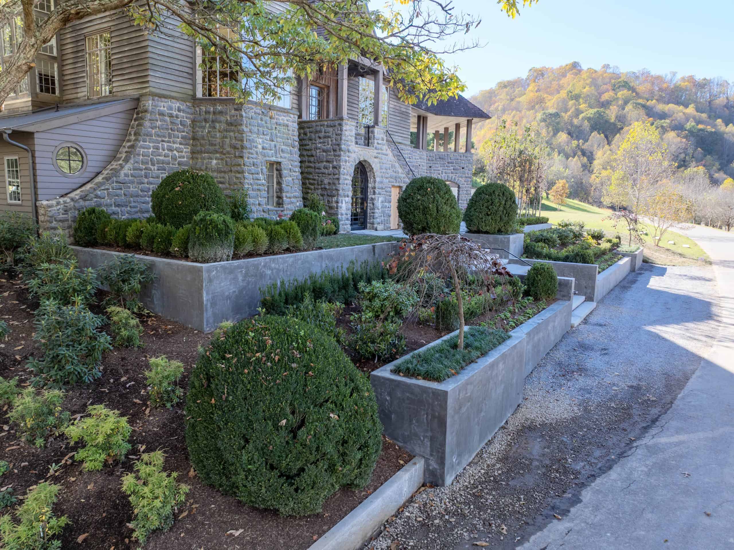 Formal boxwood spheres and structured terraced planting beds at luxury mountain estate Ahma at Cold Mountain, Canton NC