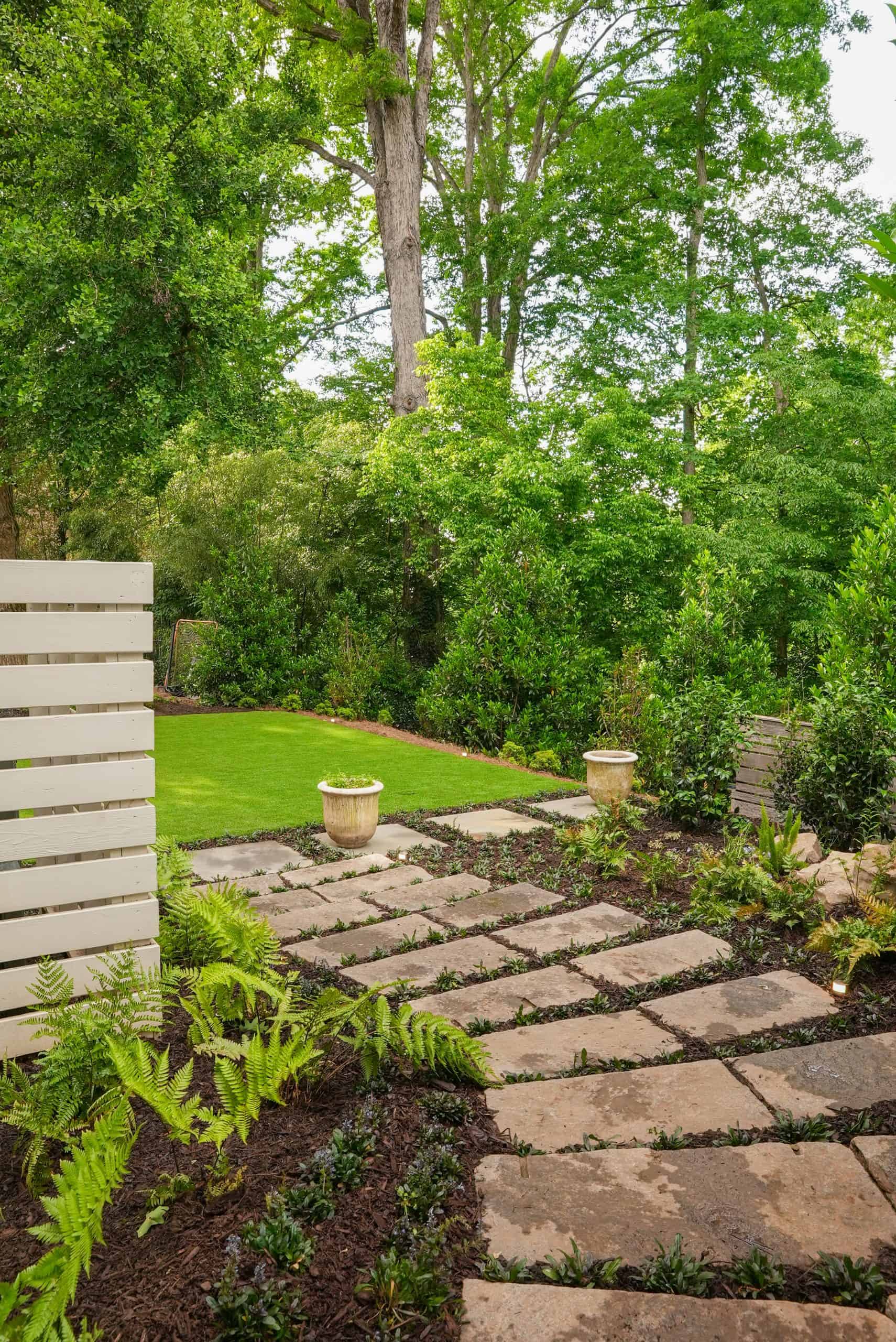 Bluestone stepping-stone path set in groundcover with ferns and low landscape lighting in a Buckhead estate garden by Garden Atlantic.